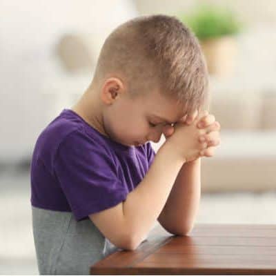 Kid in purple shirt praying