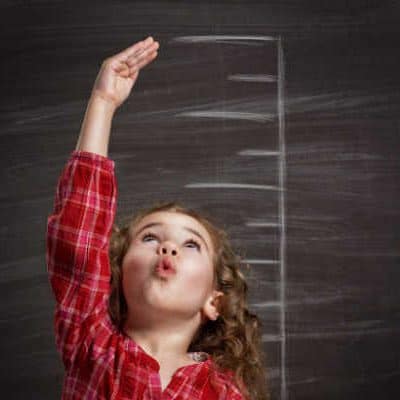 Girl in red plaid measuring up